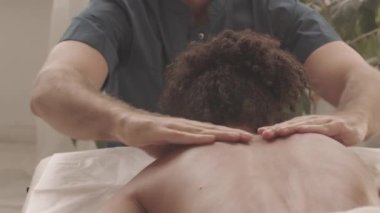 Kadın müşteriye masaj yapan erkek masaj terapisti kanepeye uzandı.