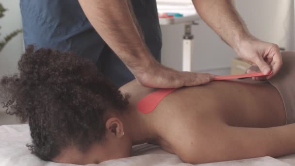 Slowmo Unrecognizable Male Chiropractor Applying Tapes Young Womans Back While — Stock Video