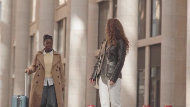 Střední Zpomalení Mladé Bělošky Setkání Afroamerickou Přítelkyní Nesoucí Kufr Před — Stock video