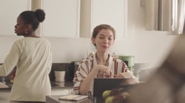 Çok ırklı mutlu lezbiyen çiftin laptopla arkadaşlarıyla görüntülü sohbetleri, evde birlikte vakit geçirmeleri.