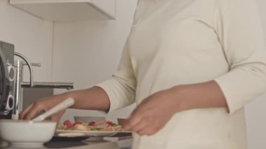 Modern minimalist tarzda mutfakta sandviç yapan siyahi kadınların yavaşlığı.