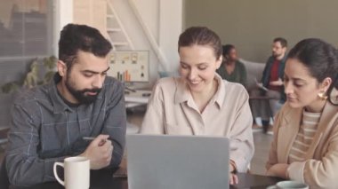 Dizüstü bilgisayarın başında oturmuş proje fikirleri geliştirirken iş arkadaşlarından oluşan orta karar bir yavaşlama.