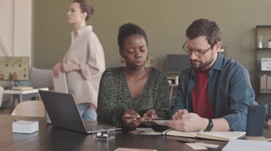 Modern ofisteki proje üzerinde çalışırken renk paletine bakan çok ırklı iki tasarımcının orta yavaşlığı