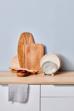 Tahta kesme tahtalarının bir sıra üzerinde duran tabaklar masanın üzerinde.