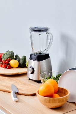 Taze meyve ve sebzelerle taze meyve suyu yapmak için elektrikli blender.