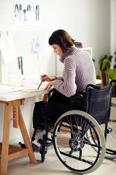 Kreatywna Młoda Projektantka Mody Wózku Inwalidzkim Sprawdza Wzór Szycia Który — Zdjęcie stockowe