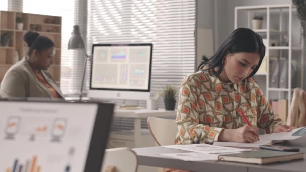 中東とアフリカ系アメリカ人女性の同僚の腰を遅くオフィスでビジネス文書を扱う — ストック動画