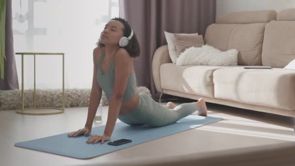 Kulaklıklı Evde Yoga Yaparken Yukarı Doğru Köpek Pozu Veren Yavaş — Stok video