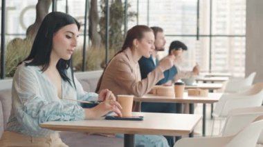 Yemek katında panoramik pencereli masalarında oturan, öğle yemeği yiyen ve kahve içen insanları yavaş yavaş bele al.