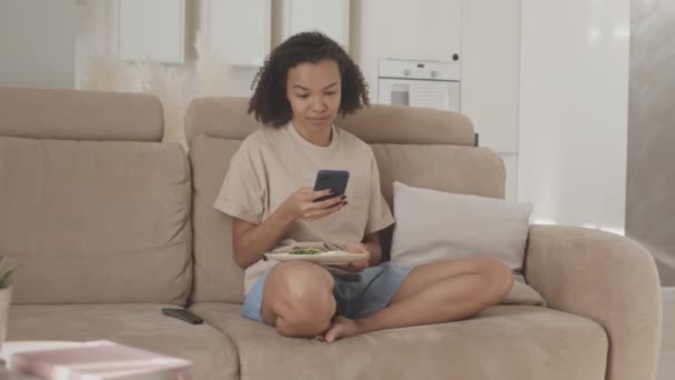 Średnie Spowolnienie Biracial Dziewczyna Homewear Siedzi Kanapie Przed Telewizorem Salonie — Wideo stockowe