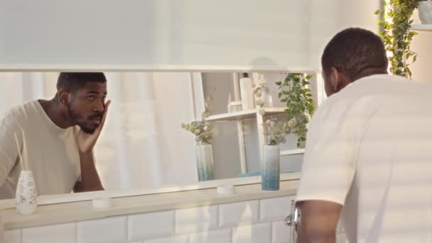 미니멀리즘 스타일의 욕실에서 거울에 자신의 모습을 남성의 느림보 — 비디오