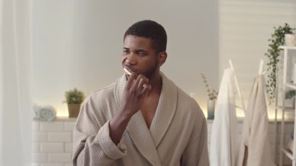 Sabahları Banyoda Dişlerini Fırçalayan Bornozlu Genç Yakışıklı Bir Adam — Stok video