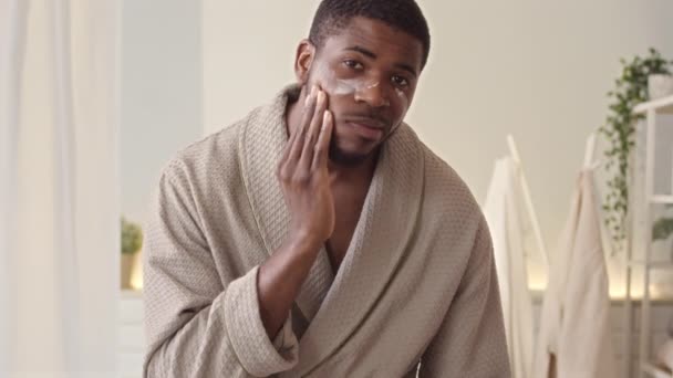 Medium Slowmo Handsome Young African American Man Bathrobe Applying Moisturizing — Stock Video