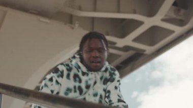 İfade gücü düşük genç siyahi adam, büyük boy kapüşonlu kapüşonlu kapüşonlu hip hop dansı yapıyor.