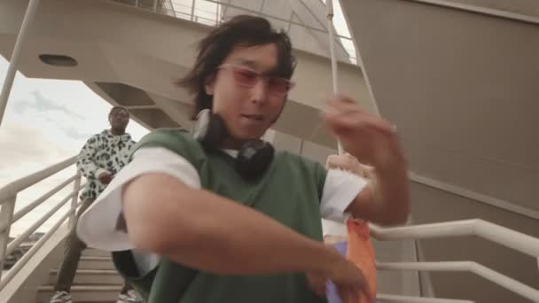 Handheld Slowmo Eines Coolen Asiatischen Jungen Mit Pinkfarbener Sonnenbrille Und — Stockvideo