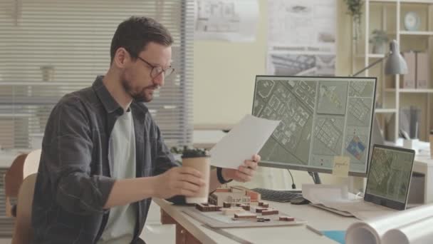 都市化プロジェクトやオフィスのインフラ整備に取り組んでいる間 コンピュータ画面上の都市マップを検討するプロの男性都市プランナーの腰の上のスローモ — ストック動画