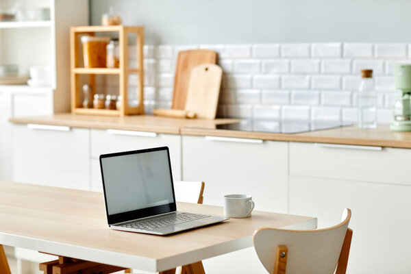 Background image of minimal home office workplace with laptop on kitchen table, copy space