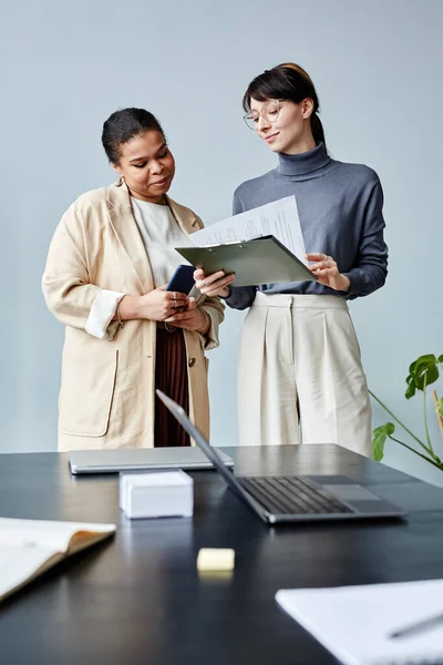 Vertical Portrait Two Young Businesswomen Reading Document While Standing Office — Stock Photo, Image