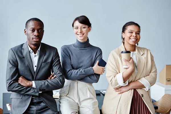 簡単な背景を背景に オフィスのカメラで笑顔3人の多様なビジネスの人々の腰の肖像画 — ストック写真