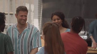 Orta yaşlı, çeşitli arkadaş grupları selamlaşırken birbirlerine sarılıyorlar, terasta akşam yemeği için bir araya geliyorlar.