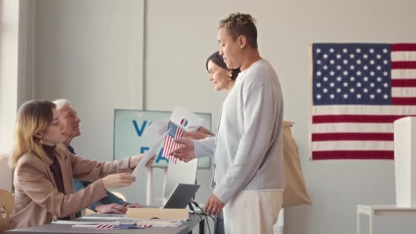 在地方选区参加美国总统选举前 持美国国旗和公告的多族裔男子和妇女的中速投票速度 — 图库视频影像