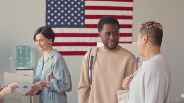中等速度慢的美国公民排队在选区排队等候工人给他们发消息时交谈 — 图库视频影像