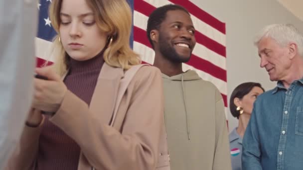 選挙日の投票所でキューに立っている多様な米国市民の低角度中低速 — ストック動画