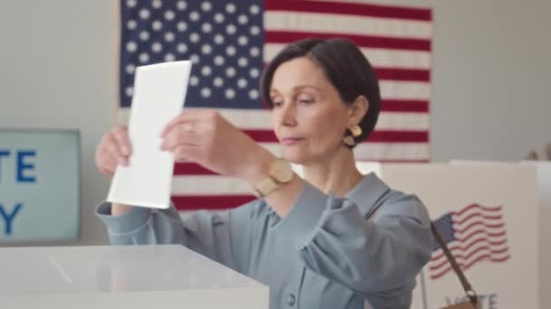 在投票站等成熟的白人妇女把选票放进投票箱的慢动作 — 图库视频影像