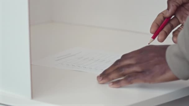无法辨认的黑人男子在选票上对候选人打上红线的特写 — 图库视频影像