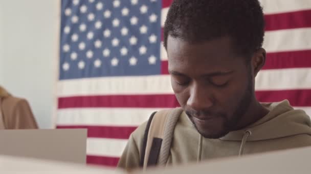 在美国选区 年轻黑人男子站在投票箱旁的慢镜头下进行中的特写 — 图库视频影像