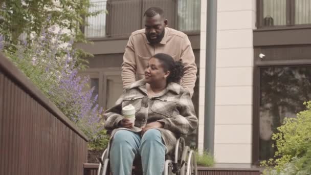 Mittlere Verlangsamung Eines Schwarzen Mannes Der Frau Rollstuhl Auf Einem — Stockvideo