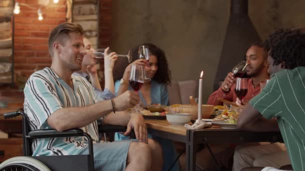 Medium Slowmo Young Caucasian Man Wheelchair Drinking Wine Talking Friends — Stock Video