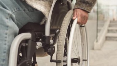 Orta bölüm, tekerlekli sandalyeyle gezen, tanınmayan bir kadının yavaş çekimleri.