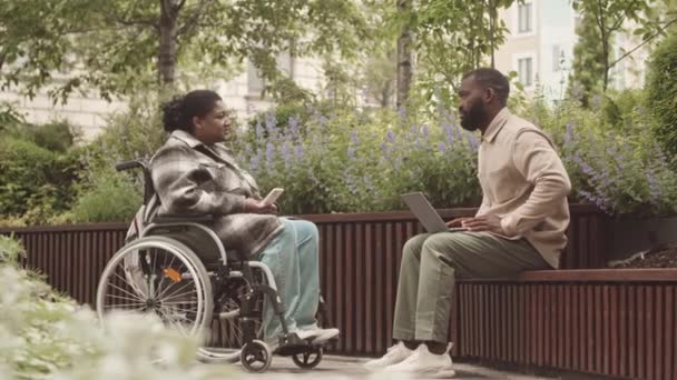 휠체어에 아프리카 미국인 야외에서 공원에서 일하는 이야기하는 전반적 — 비디오