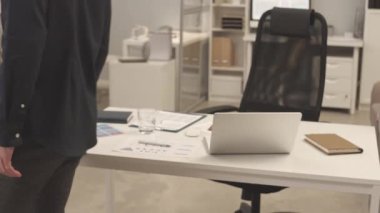 İki farklı erkek meslektaşın yavaşça el sıkışarak iş yerlerinde birbirlerini selamlamaları.