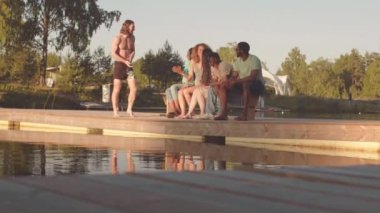 Yazın arkadaşlarıyla dışarıda takılırken, yavaş yavaş iskeleden atlayan Kafkasyalı genç adam.