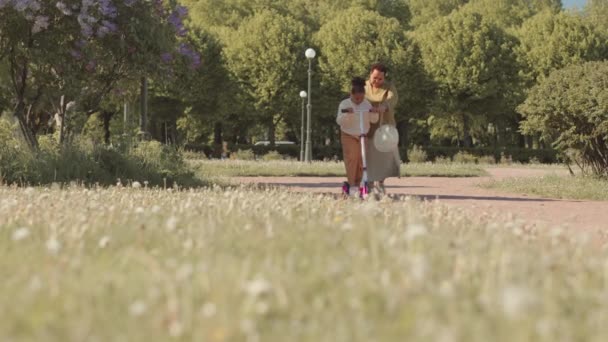 Küçük Kızına Güneşli Bir Günde Parkta Scooter Sürmeyi Öğreten Afrikalı — Stok video