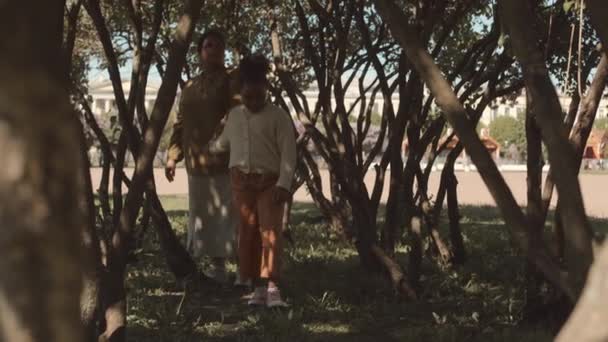 Slowmo Afroamerykańskiej Matki Córki Spacerujących Pod Gałęziami Liliowego Drzewa Parku — Wideo stockowe