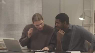 Ofis masasında evrak işleriyle uğraşan, bütçeyi planlayan ve proje detaylarını tartışan iki farklı erkek meslektaşı ağırdan alalım.