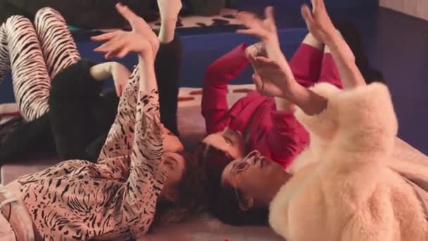 流行のピンクの光と投票とレトロなスタジオで床に横たわっているヴィンテージ衣装でスタイリッシュなダンサーのチームのスロー — ストック動画