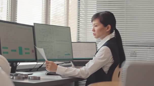 オフィスで設計図を操作しながら カメラのためにポーズ若い女性アジアのエンジニアの腰アップ遅い肖像画 — ストック動画