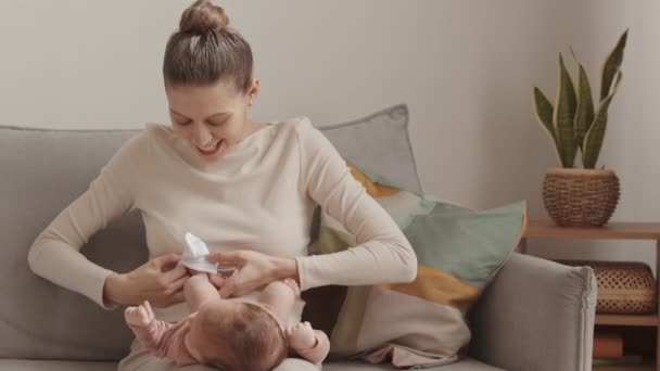 Medium Slowmo Happy Young Mother Putting Tiny White Socks Little — Stock Video