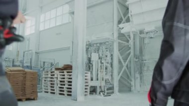 Medium shot of African American female factory worker explaining plan of work to new colleague, working together at natural stone processing plant