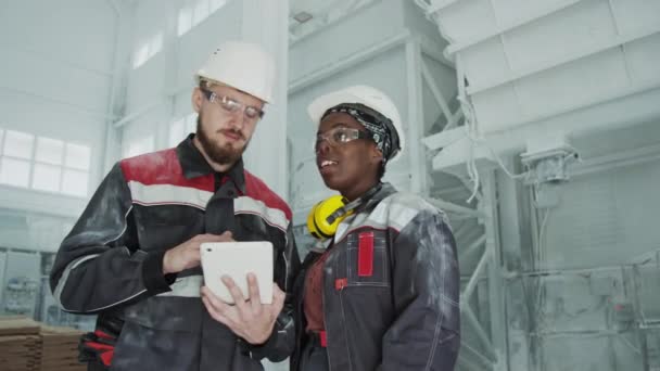 Medium Shot Multiethnic Couple Engineers Uniforms Hard Hats Working Together — Video Stock