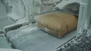 Bags with marble aggregate on conveyor at natural stone processing factory