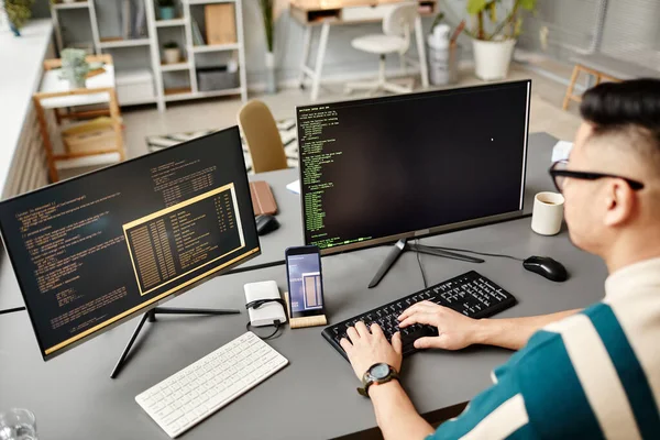 사무실 내부에서 일하는 컴퓨터 화면상에서 프로그래밍 코드로 키보드로 타이핑하는 개발자의 — 스톡 사진