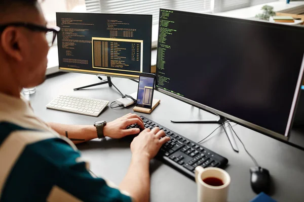 사무실 내부에서 일하는 컴퓨터 화면상에서 프로그래밍 코드로 키보드로 타이핑하는 개발자의 — 스톡 사진