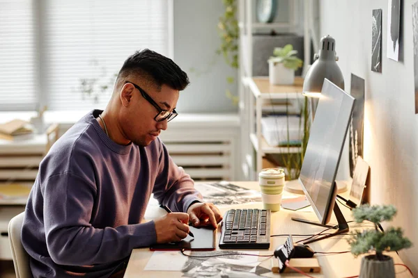 Stock image Portrait of Asian male creator retouching photographs at home office workplace and using pen tablet