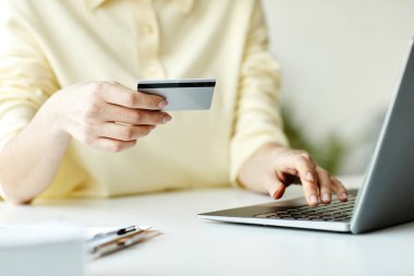 Bilgisayardan kredi kartı ile ödeme yapan tanınmayan bir kadın bir şey satın alıyor.