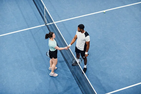 試合中にネット上で握手する2人のテニス選手の最小トップビュー コピースペース — ストック写真